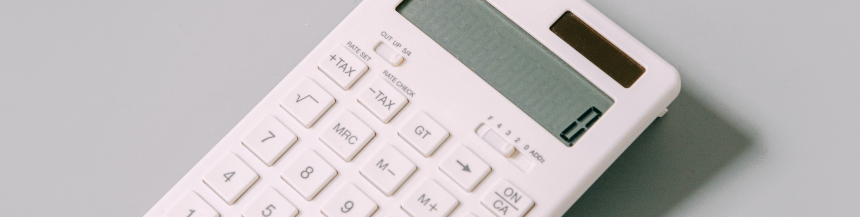 White calculator sitting on a grey surface